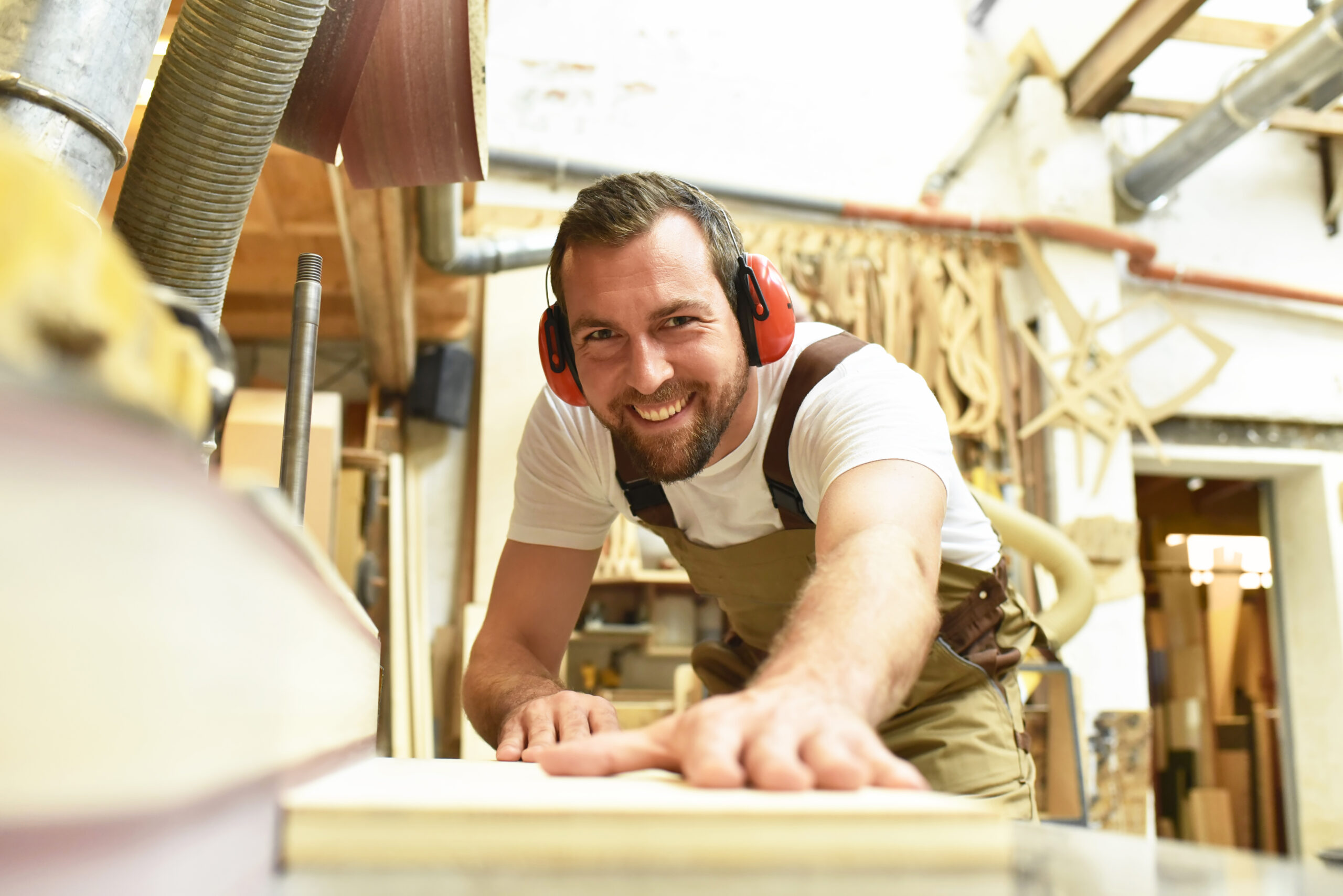 carpenter works in a joinery - workshop for woodworking and sawi