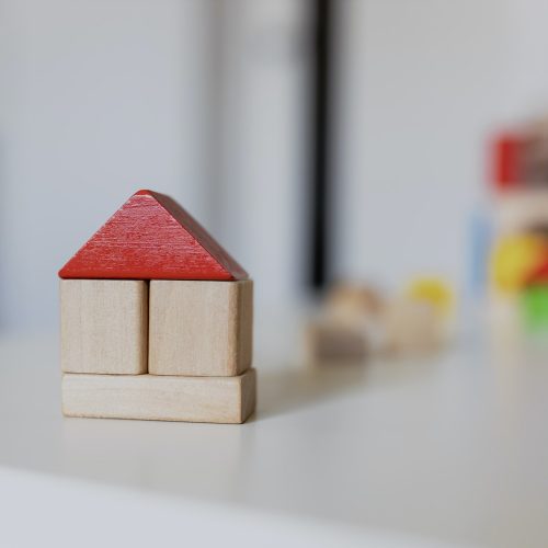 Child girl playing with colorful wooden toy building blocks